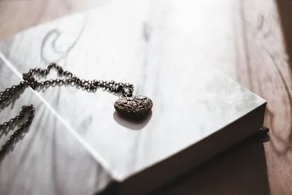 Photo of a pendant necklace resting on a book.