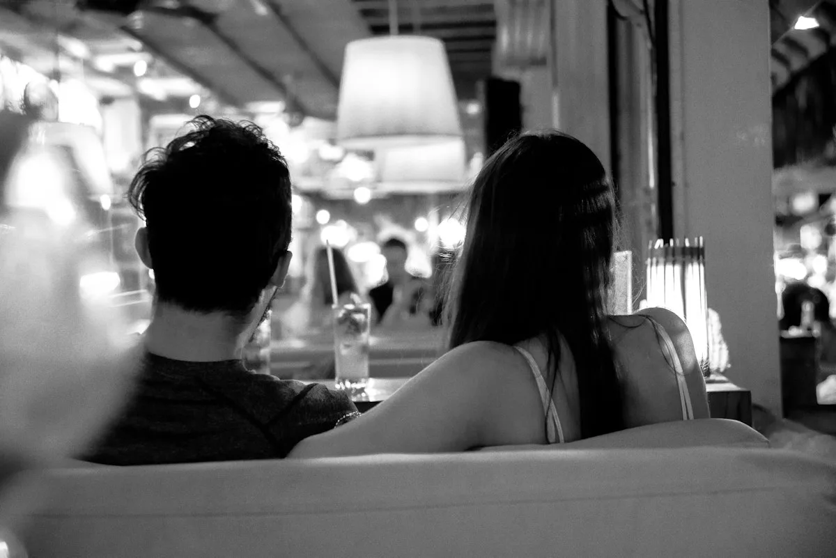 A couple sitting silently side by side, like brother and sister.