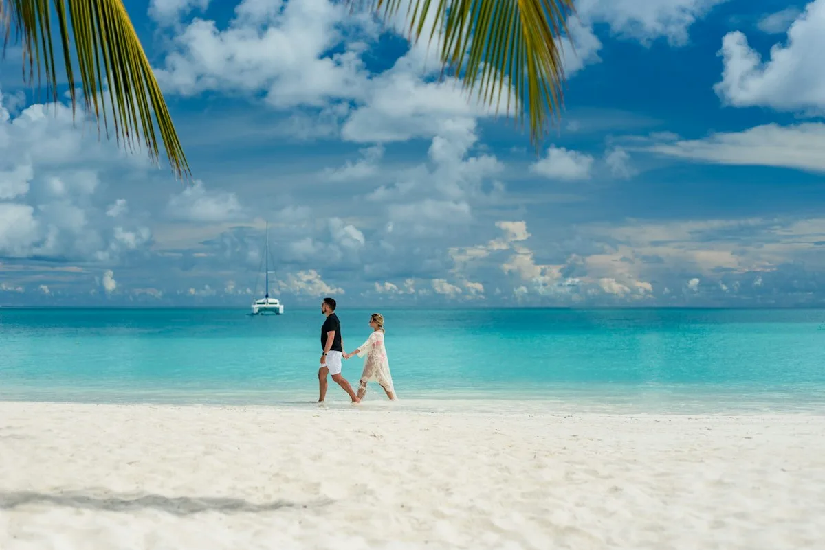 A couple walking together on the beach, each with a bit of space.