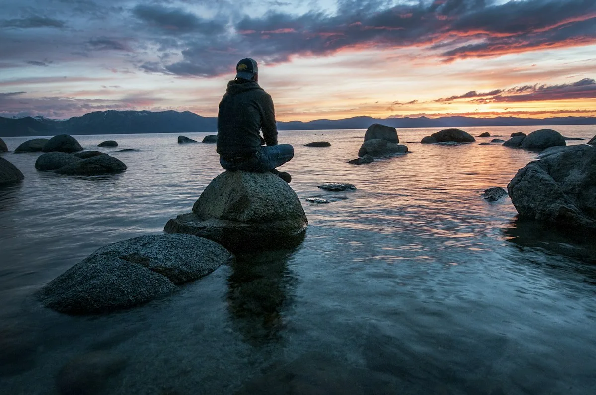 Someone sitting calmly by the water.