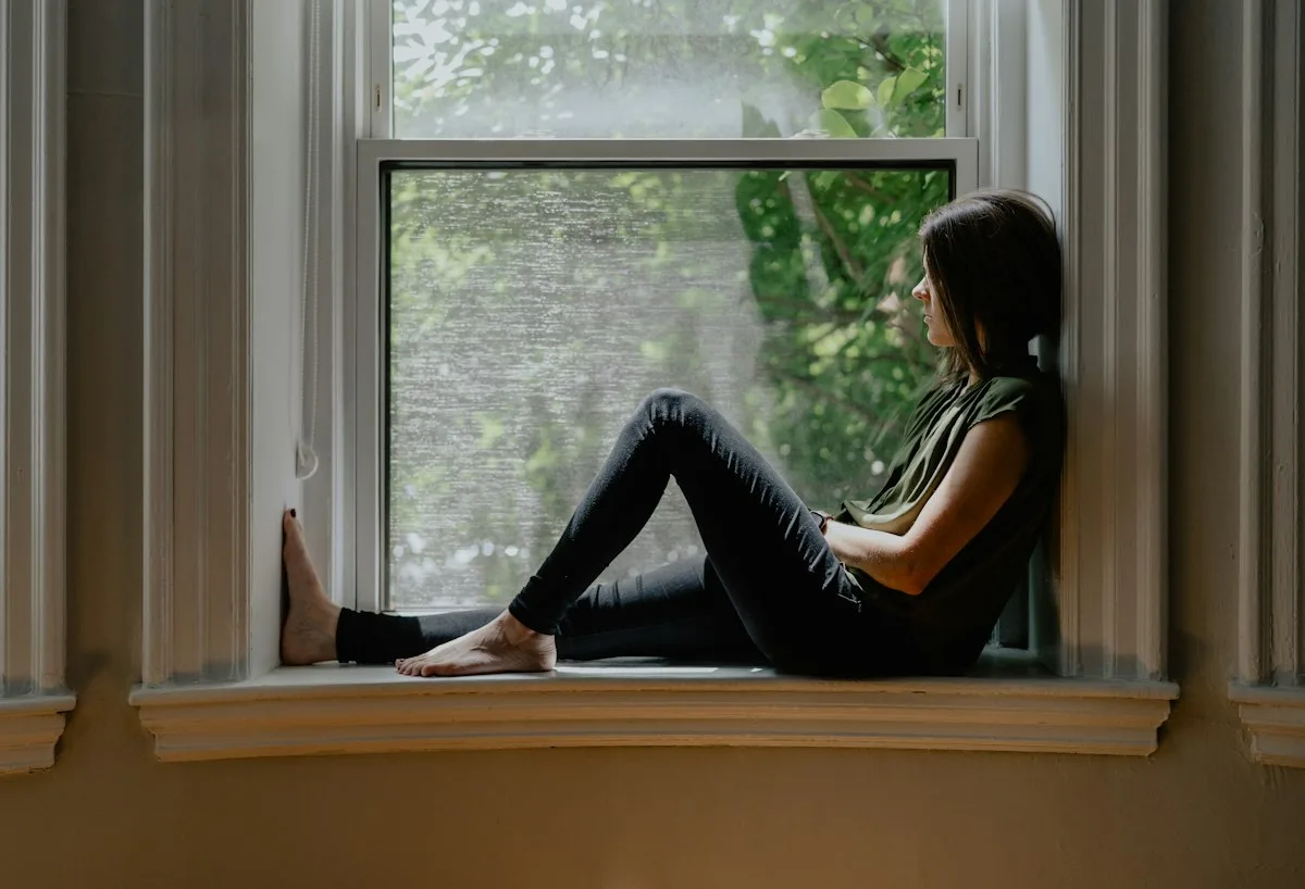 Someone sitting thoughtfully on the windowsill.