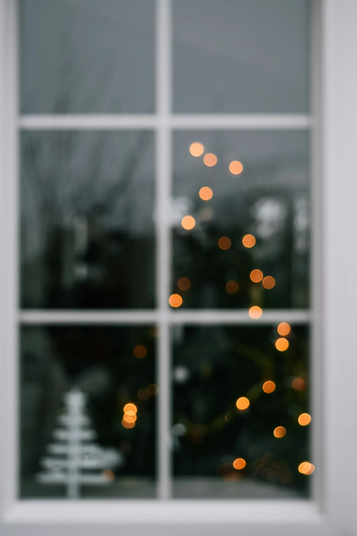 A Christmas tree seen through a window.