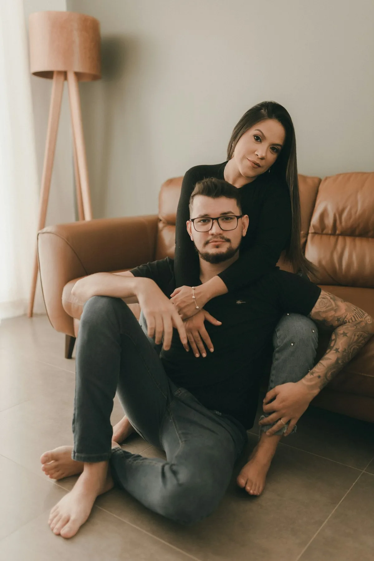 A couple sitting together on the couch at home.